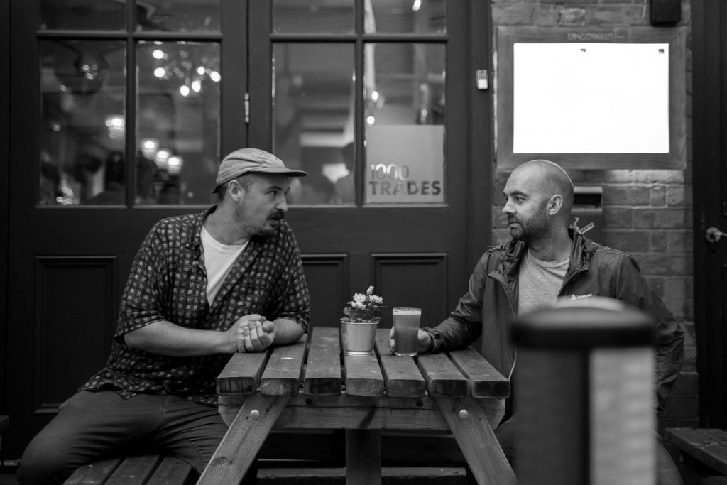 Sam and John sitting outside of 1000 Trades