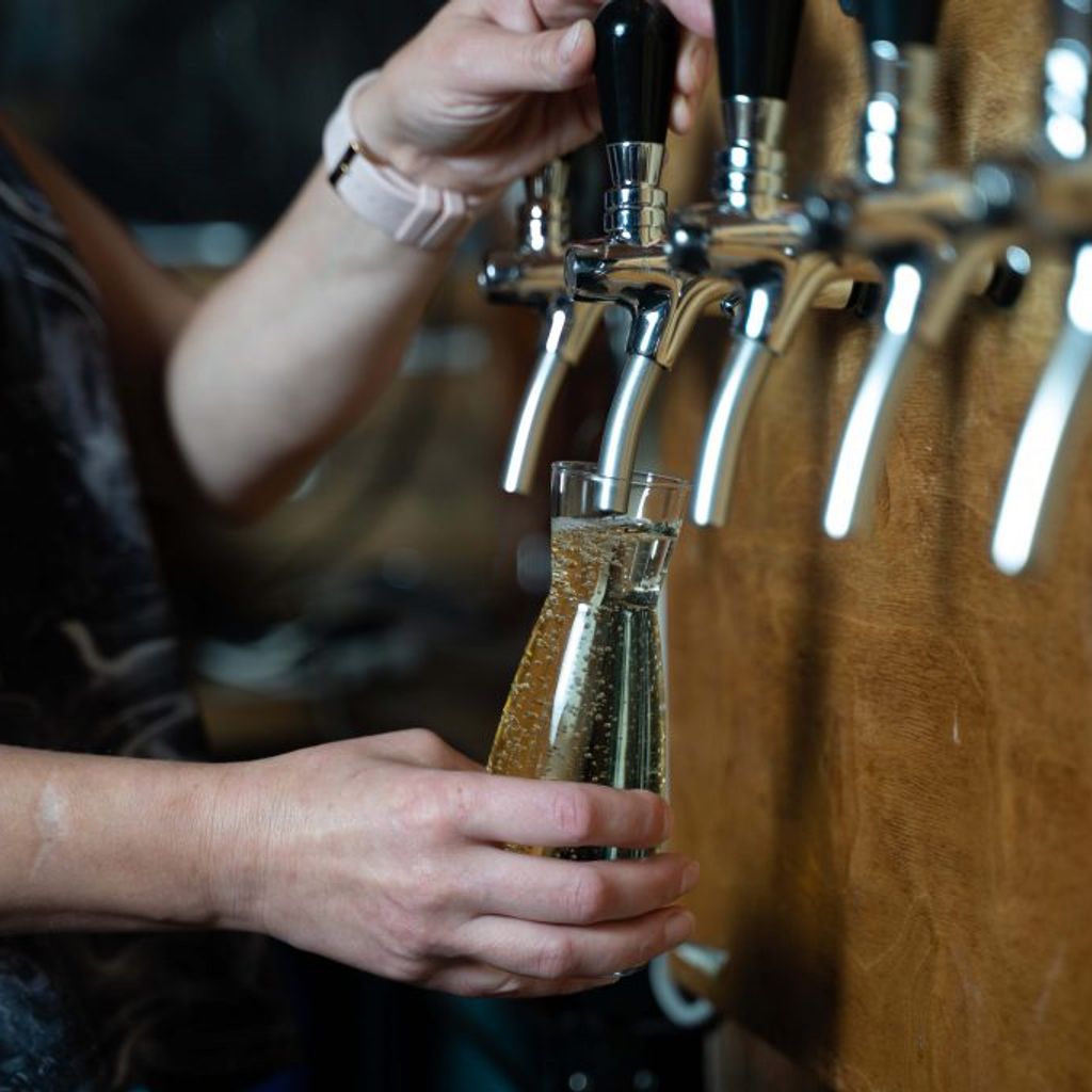 staff member pouring wine on tap
