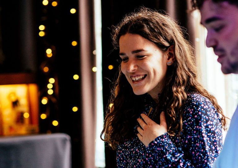 female and male member of staff, standing and laughing